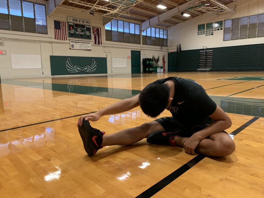 Adonis Espania stretching in preparation for the Boys varsity basketball game. 