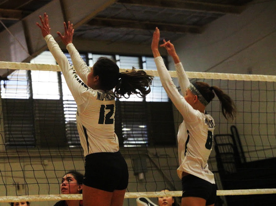 Zannah Suehiro, grade 12, spikes down the ball during a game against Iolani with support from Kayla Marutani, grade 12. 