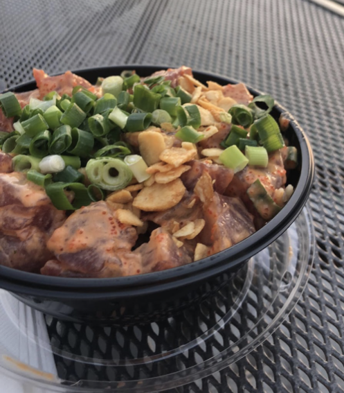 Large poke bowl with white rice, mild shoyu, furikake, spicy tuna, green onions and garlic chips about to be devoured.