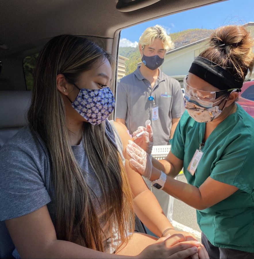 Na Pueo reporter Chelsee Sawai receives her annual flu shot from a nurse while in her car on Oct. 9. Mid-Pacific hosted their first-ever flu shot drive-thru clinic to take safety precautions during the COVID-19 pandemic while still offering students, faculty, and their family members the opportunity to get vaccinated.