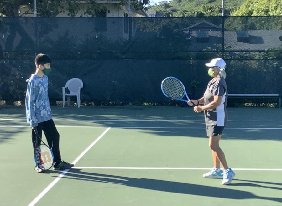 Coach Carolyn Katayama helping freshman Kekai Moriwake with swing.