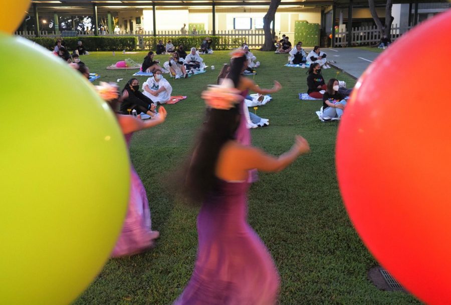 Pupukahi dancers perform for the Aloha Program as senior watch socially distanced on mats. 