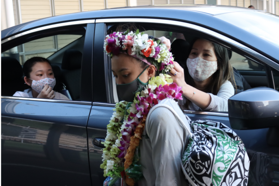 Parents adorn Zoe Oshiro with a haku lei. Parents celebrated athletes in a drive-through. 