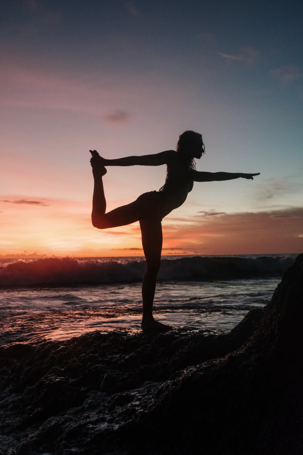 A woman does yoga while at the beach. Students have been able to find personal meaning to spirituality. 