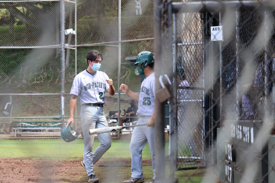 Two seniors share an encouraging fist bump while playing baseball on May 1.
