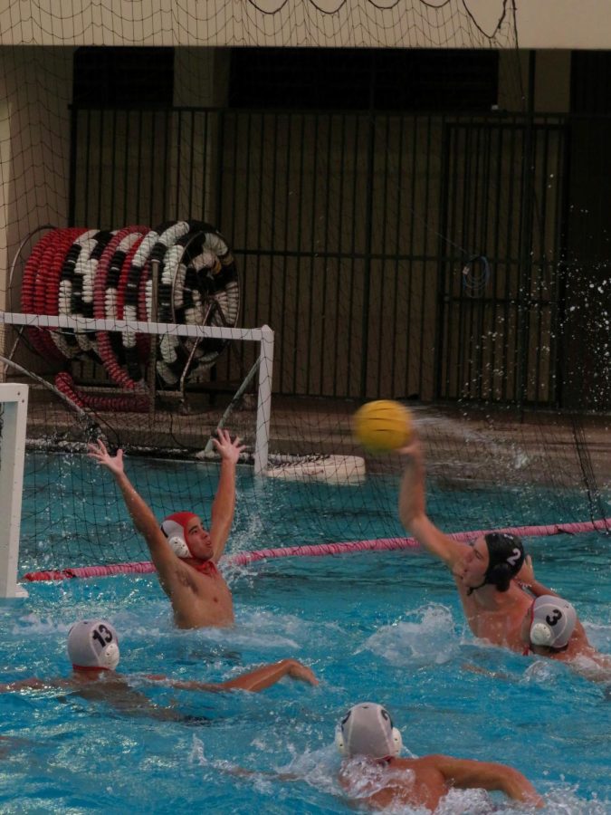 Senior Aiden Morris takes a shot on goal against Iolani defender.