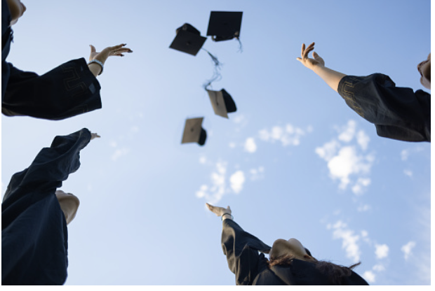 Students toss their caps in the air as they transition from high school students to a group of alumni.