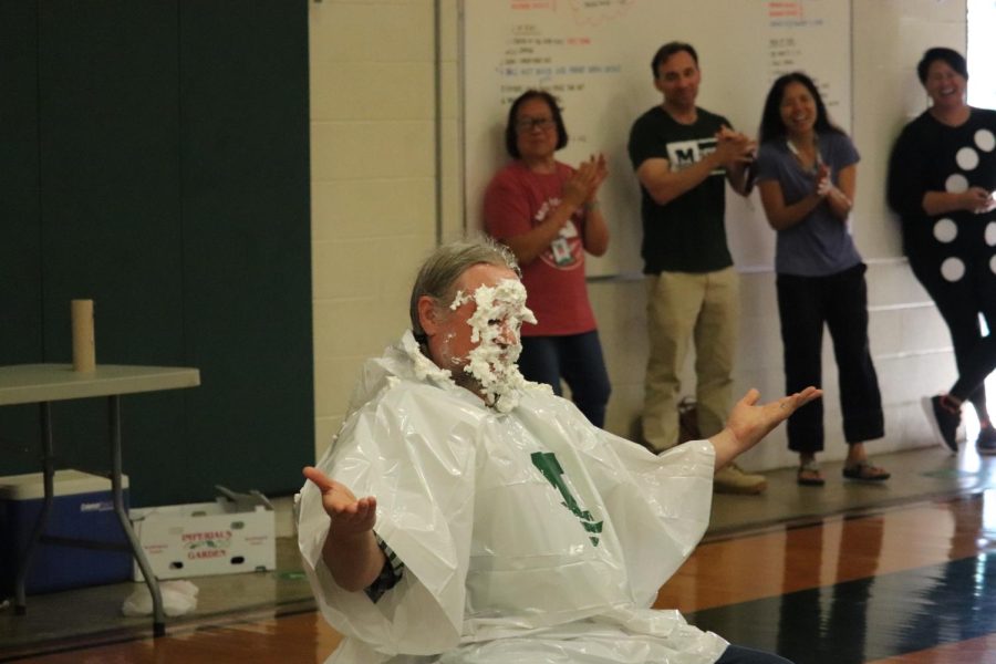 Mr. Falk holds his hand out as pie-filling drips down his face.