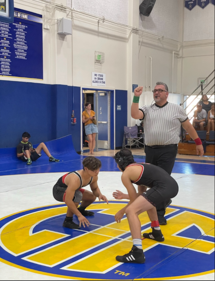 Wresting Caption Logan Lau crouching in front of his opponent.