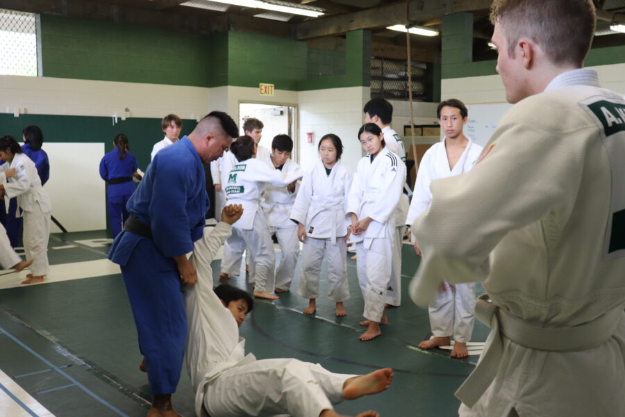 Head Judo Coach Clifton Teshima demonstrates a throw on a junior varsity student.