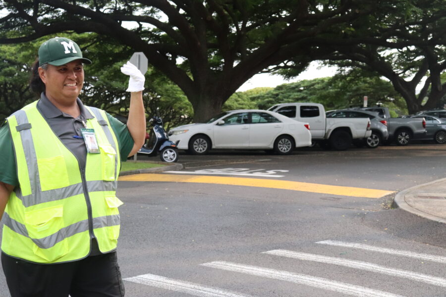 Security guard Cindy Dela Cerna smiles as she waves in cars.