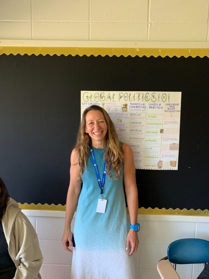 April Babcock, the new Global Politics teacher, in front of one of the posters in her classroom.