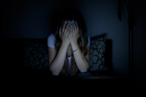 Young girl stressed as she sits in front of her computer 