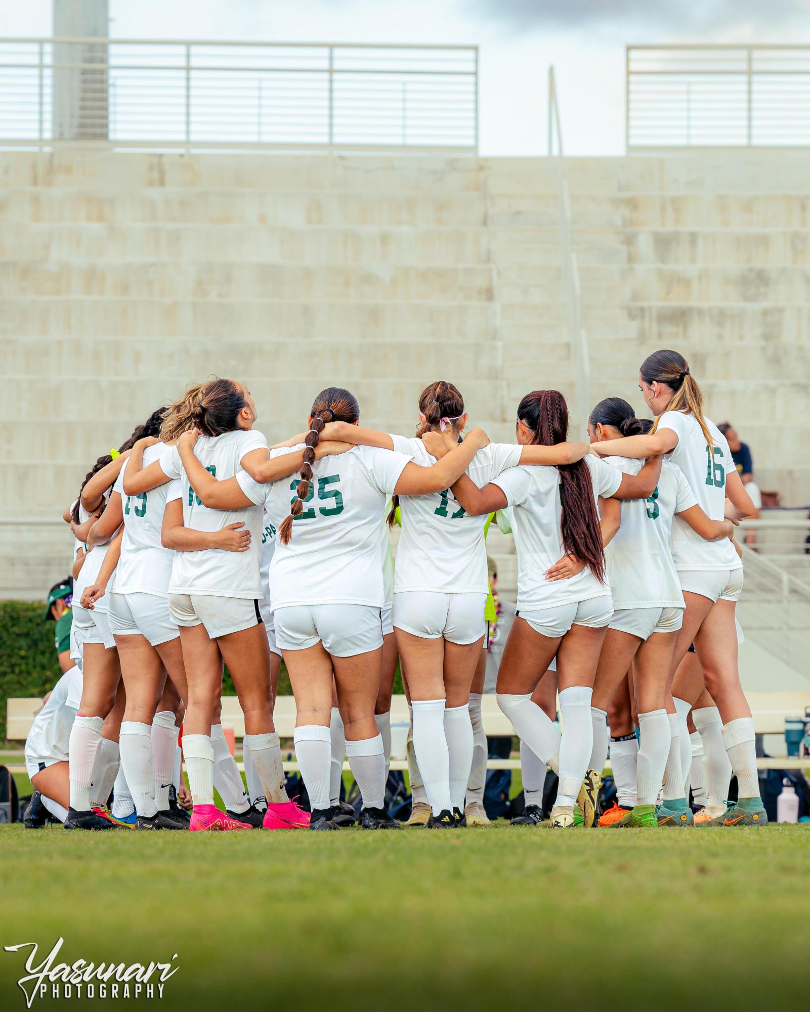 Girls Varsity team huddles for a photo